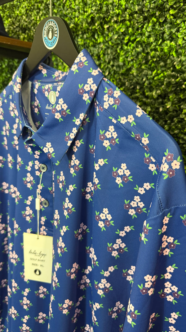A blue button-up polo with a pink and green floral print
